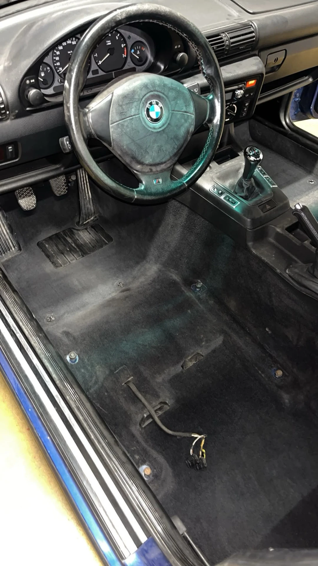 Habitacle BMW E30 après rénovation — moquette aspirée et intérieur impeccable